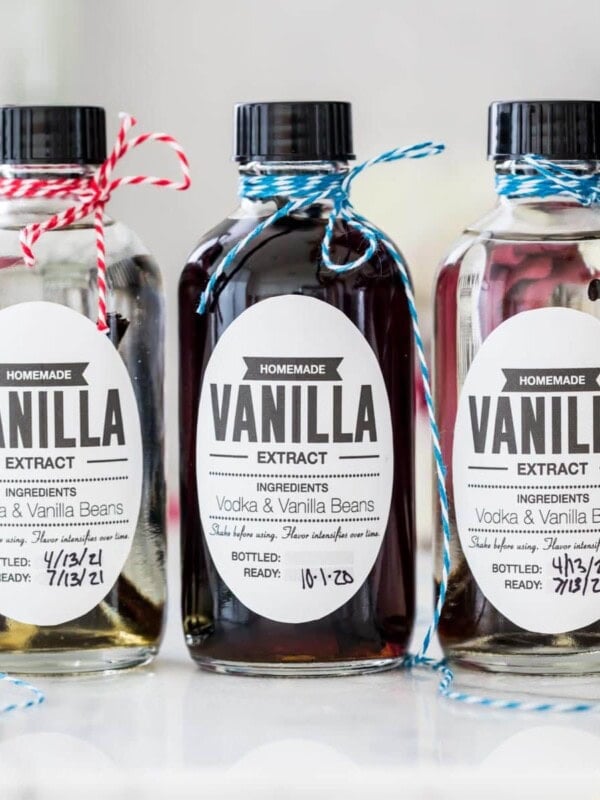 Three bottles of homemade vanilla extract with different color string on the tops