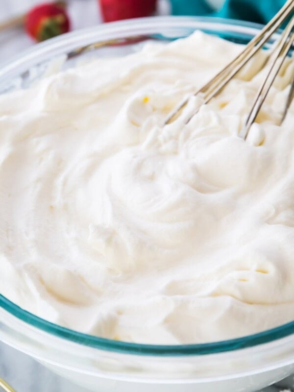 Bowl of whipped cream with a whisk.