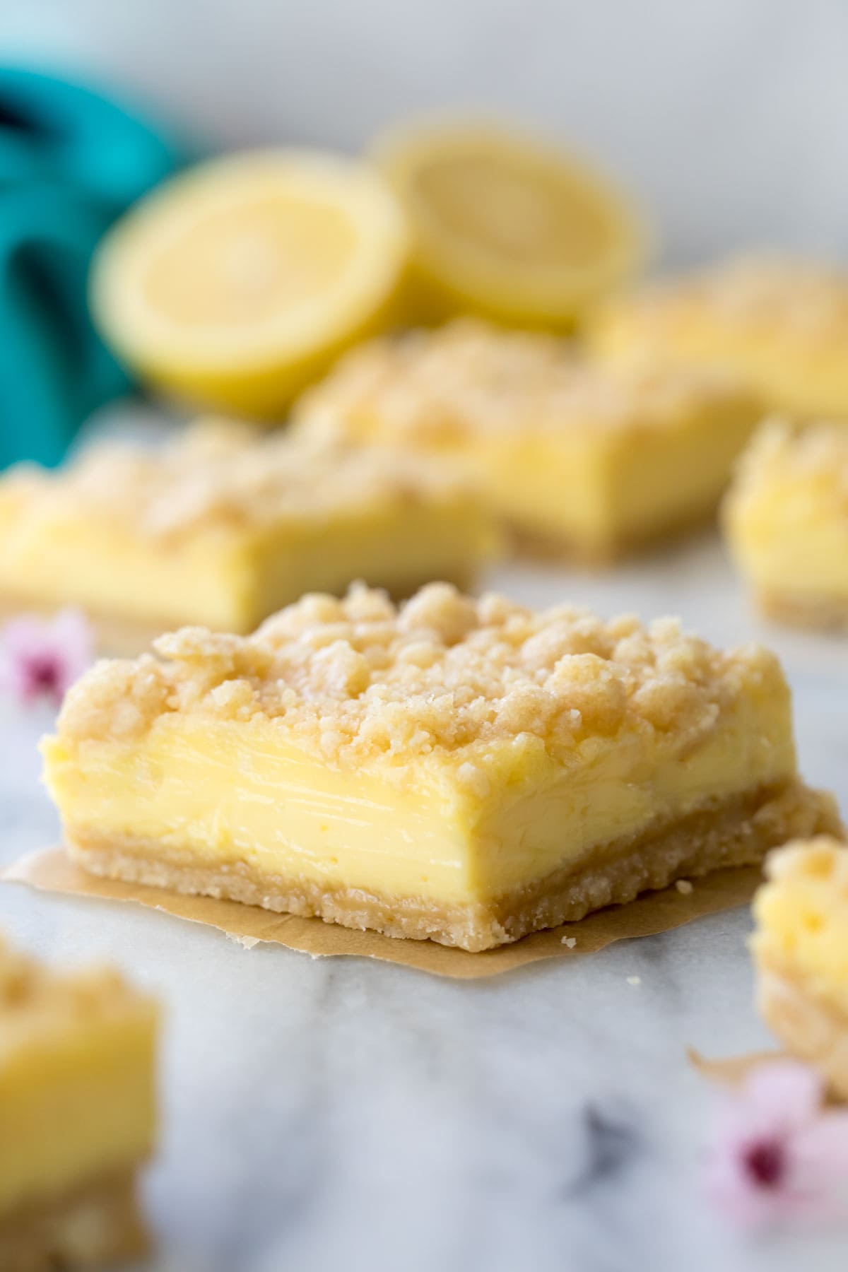 Single lemon bar on a parchment paper square.