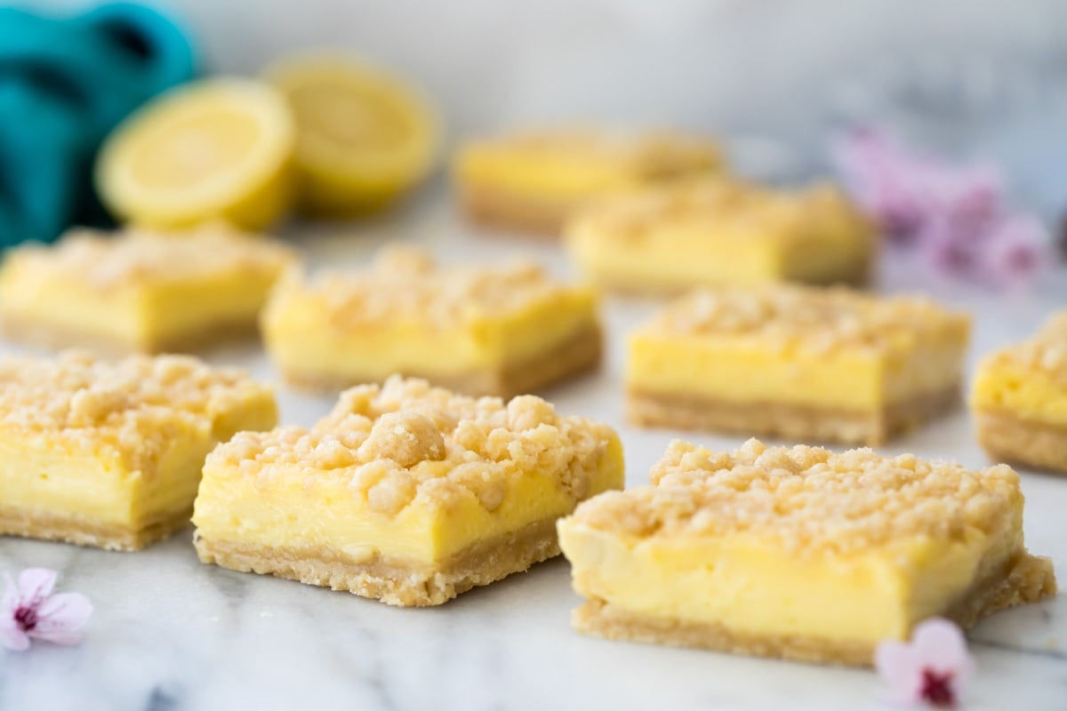 Lemon crumb bars spaced apart on top of gray marble.