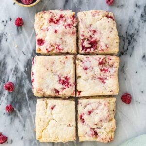 Overhead shot of six raspberry scones on gray marble