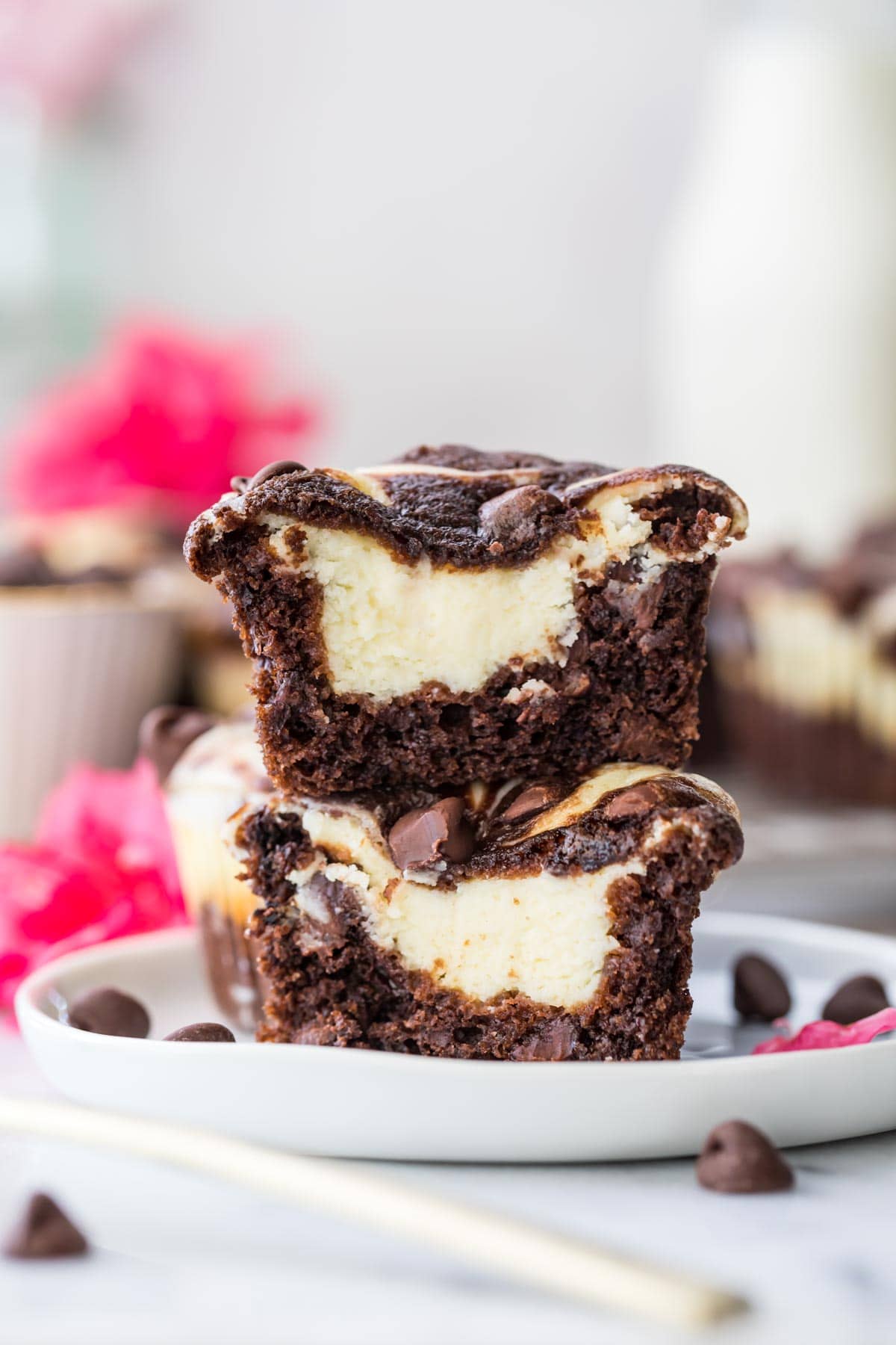 a chocolate cheesecake muffin cut in half and stacked on top of itself to show creamy cheesecake center.