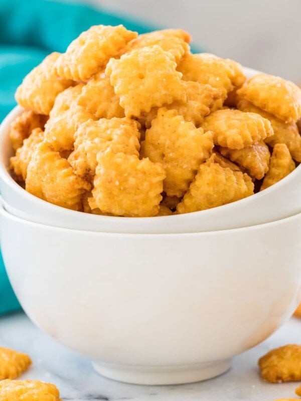 Stacked white bowls overflowing with homemade cheese crackers
