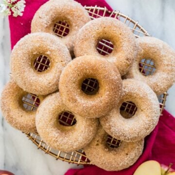 Top-down view of nine apple cider donuts on cooling rack