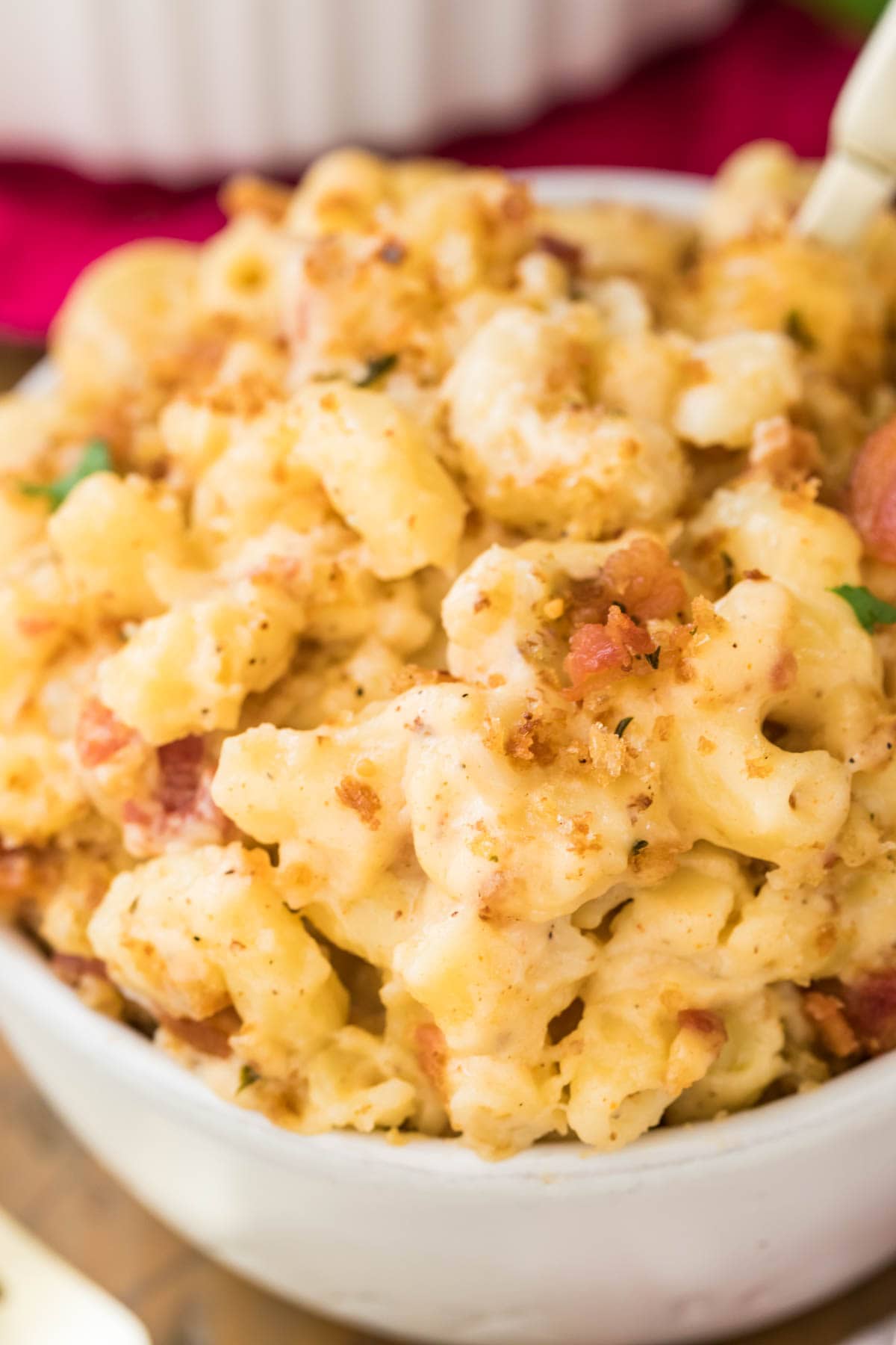 zoomed in view of bowl full of bacon mac and cheese topped with crispy bacon and panko
