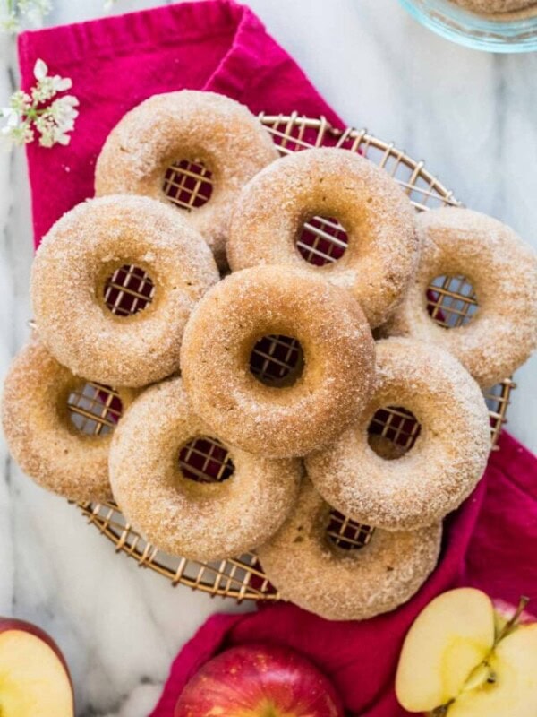 Top-down view of nine apple cider donuts on cooling rack