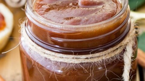 Rich brown apple butter recipe in a glass jar tied with twine