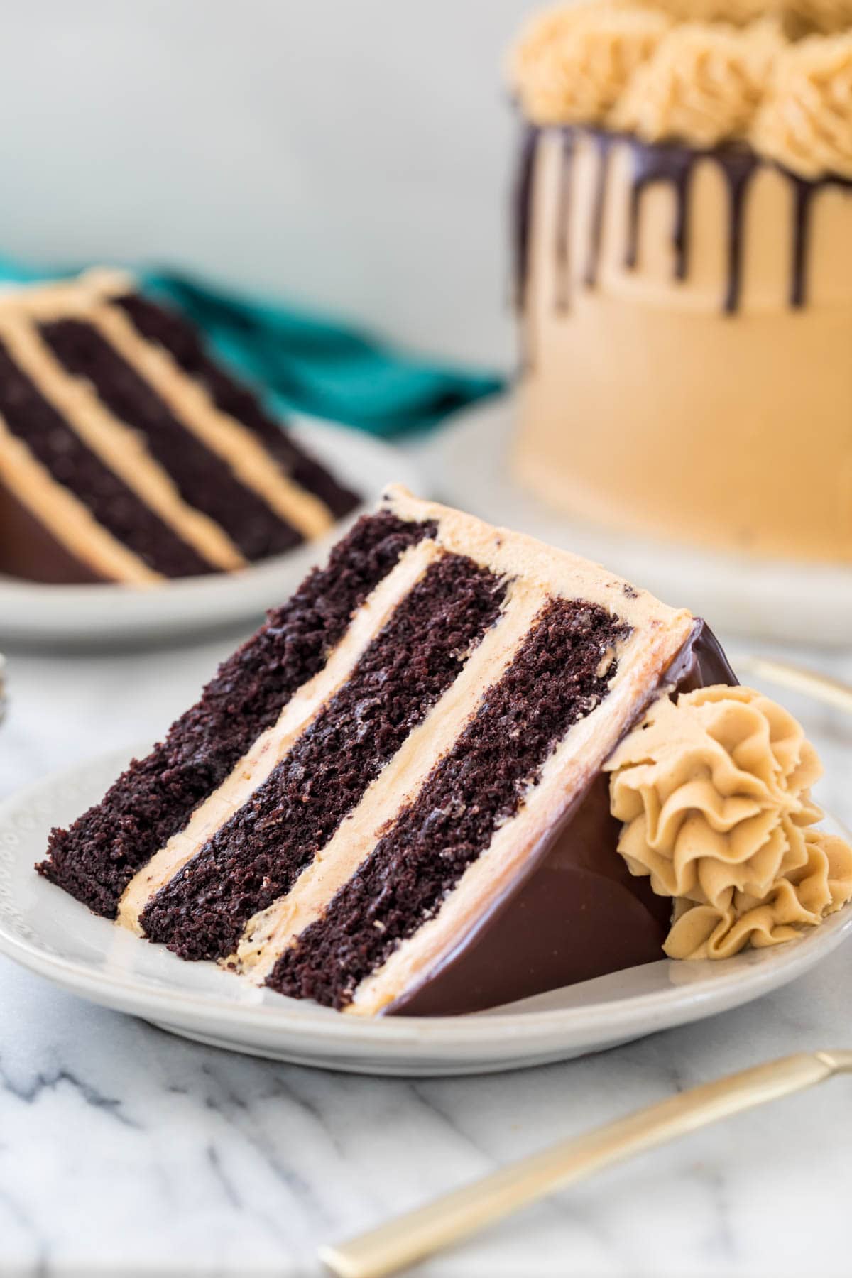 slices of three-layer peanut butter chocolate cake on white plates