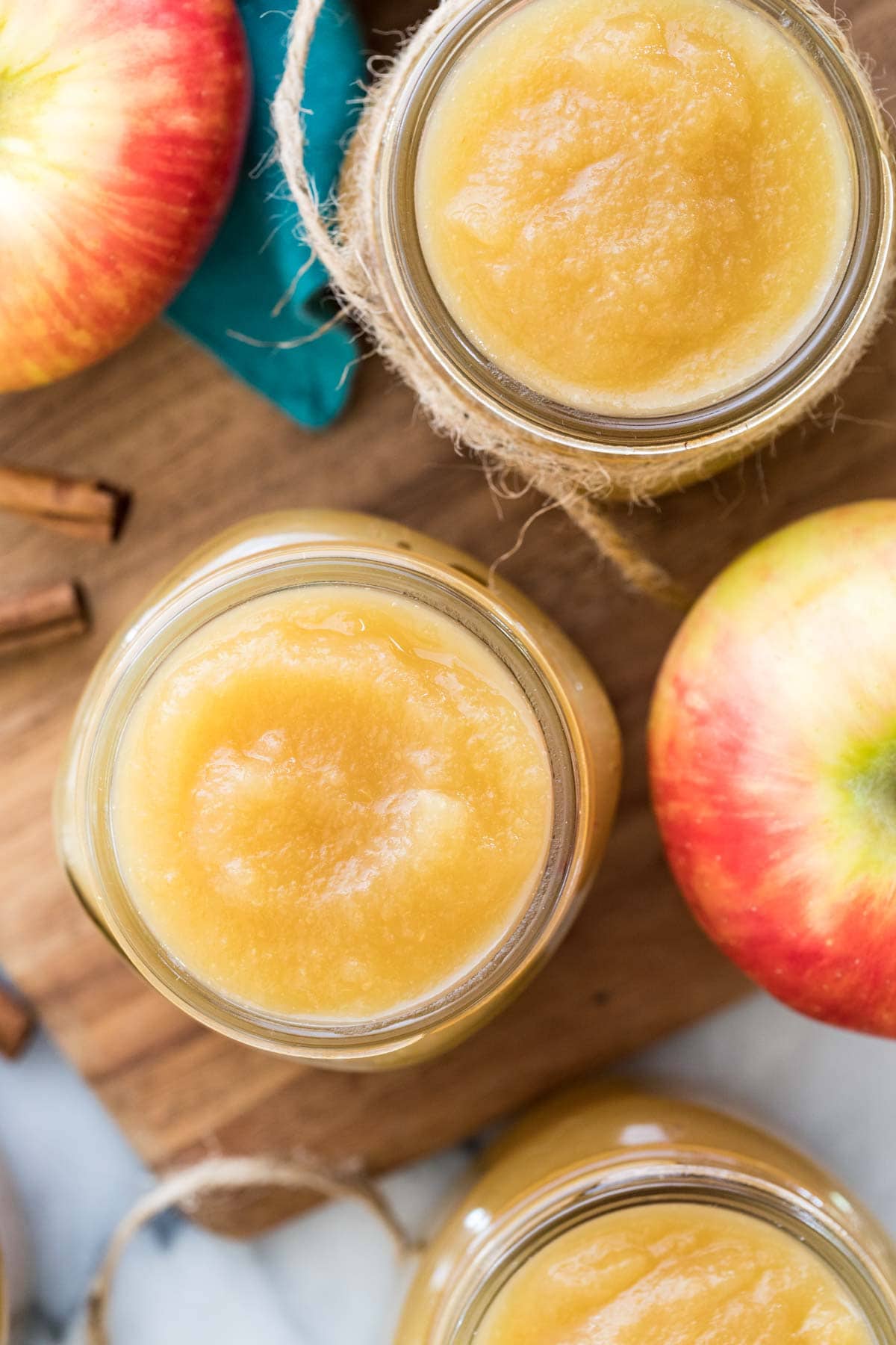 Overhead view of glass jars filled with applesauce made from a homemade applesauce recipe