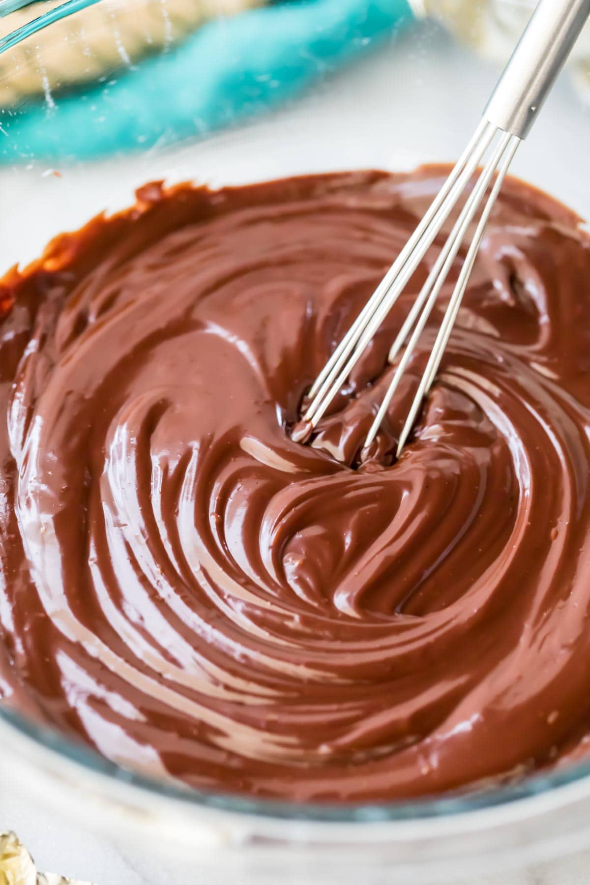 silky chocolate ganache being stirred with whisk