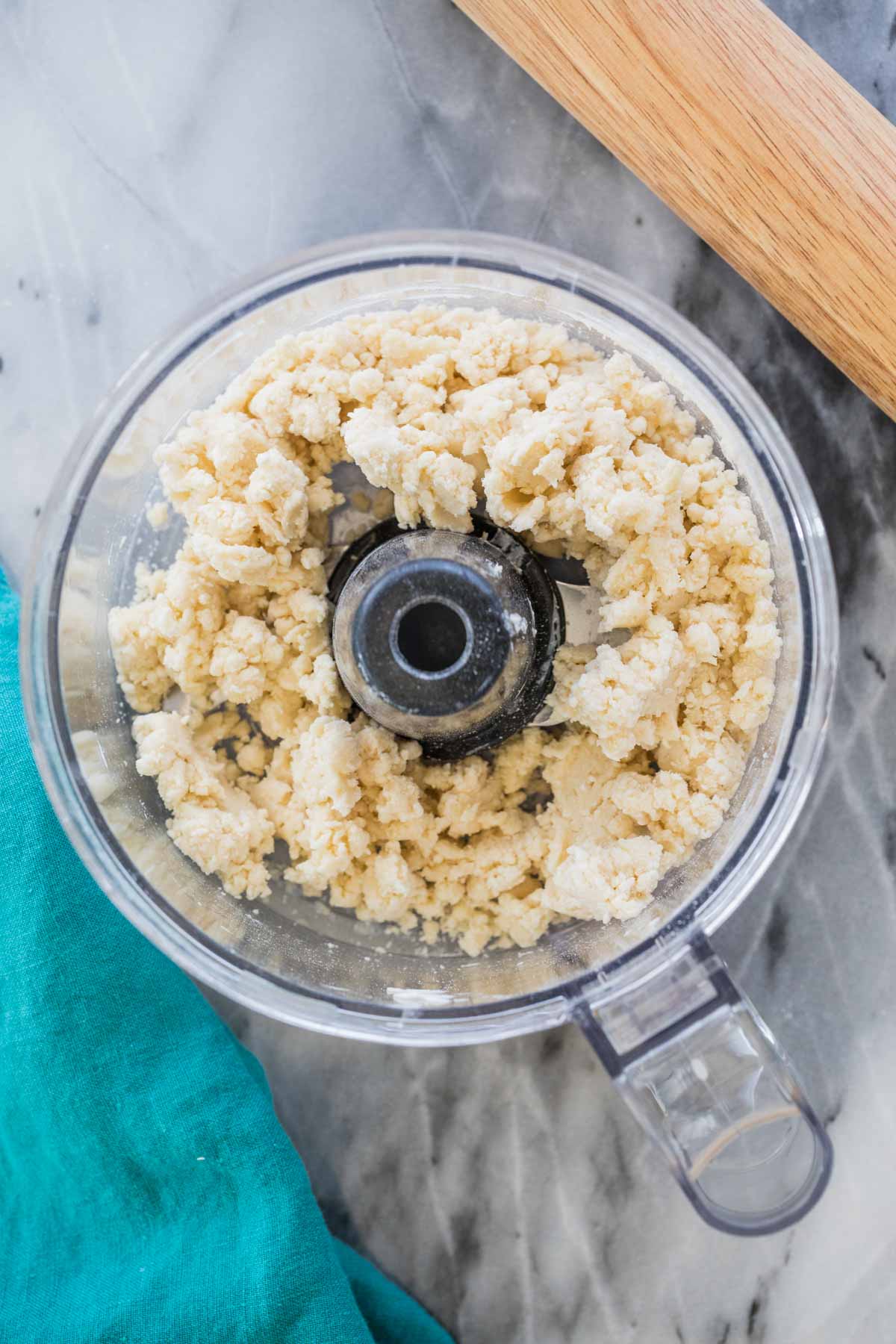 Homemade pie crust dough clinging together in food processor