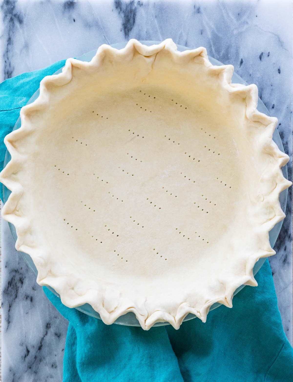 unbaked pie crust that's been docked before blind baking