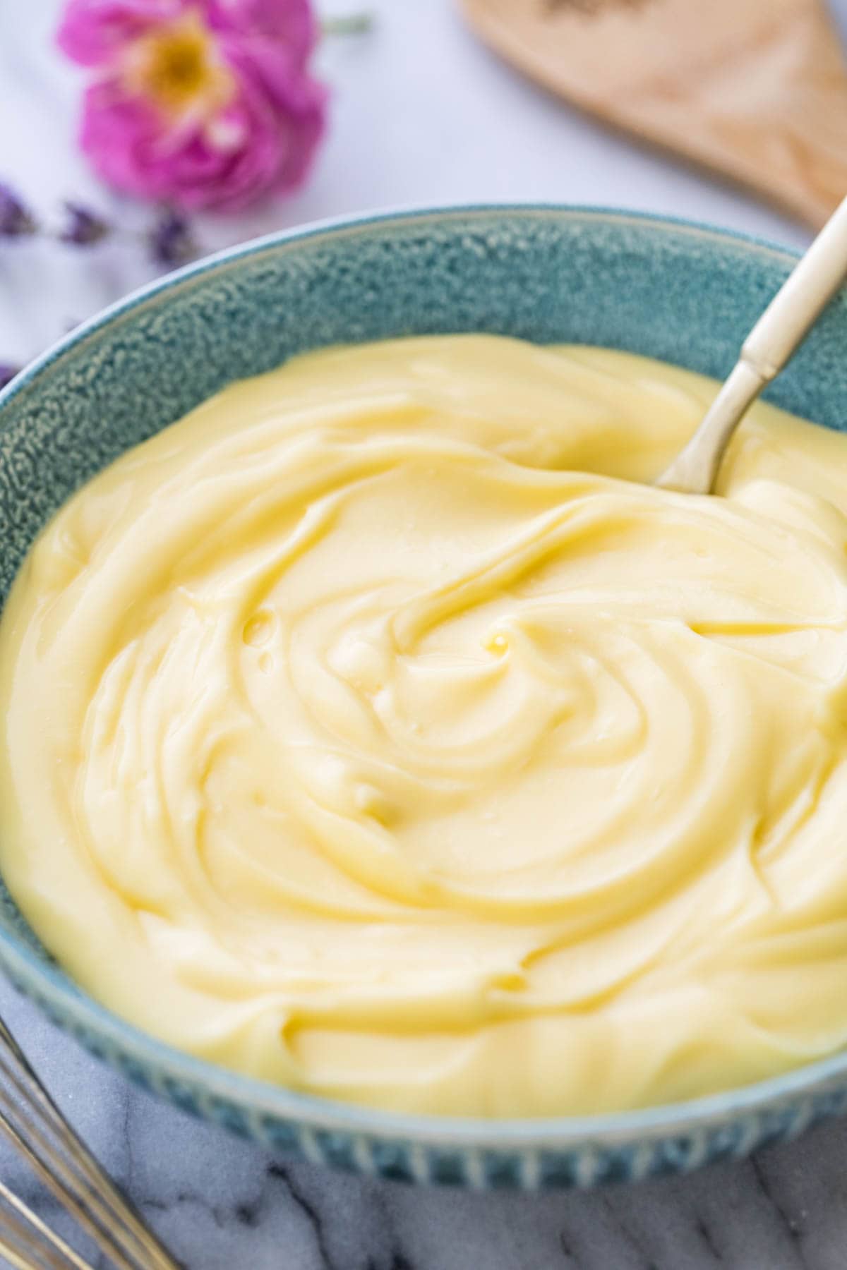 blue bowl full of thick, swirled pastry cream