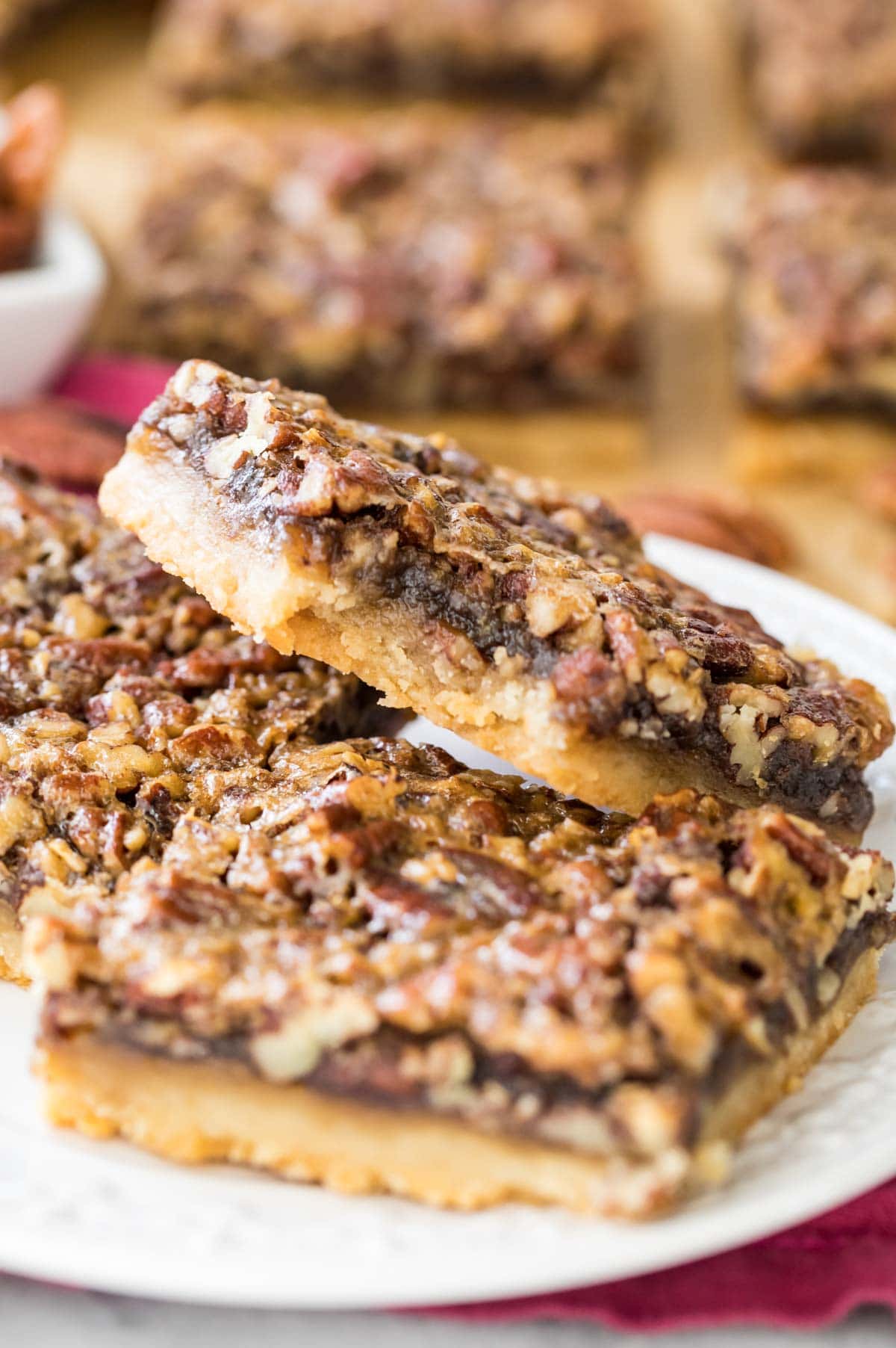 pecan pie bar with bite missing on plate with other bars