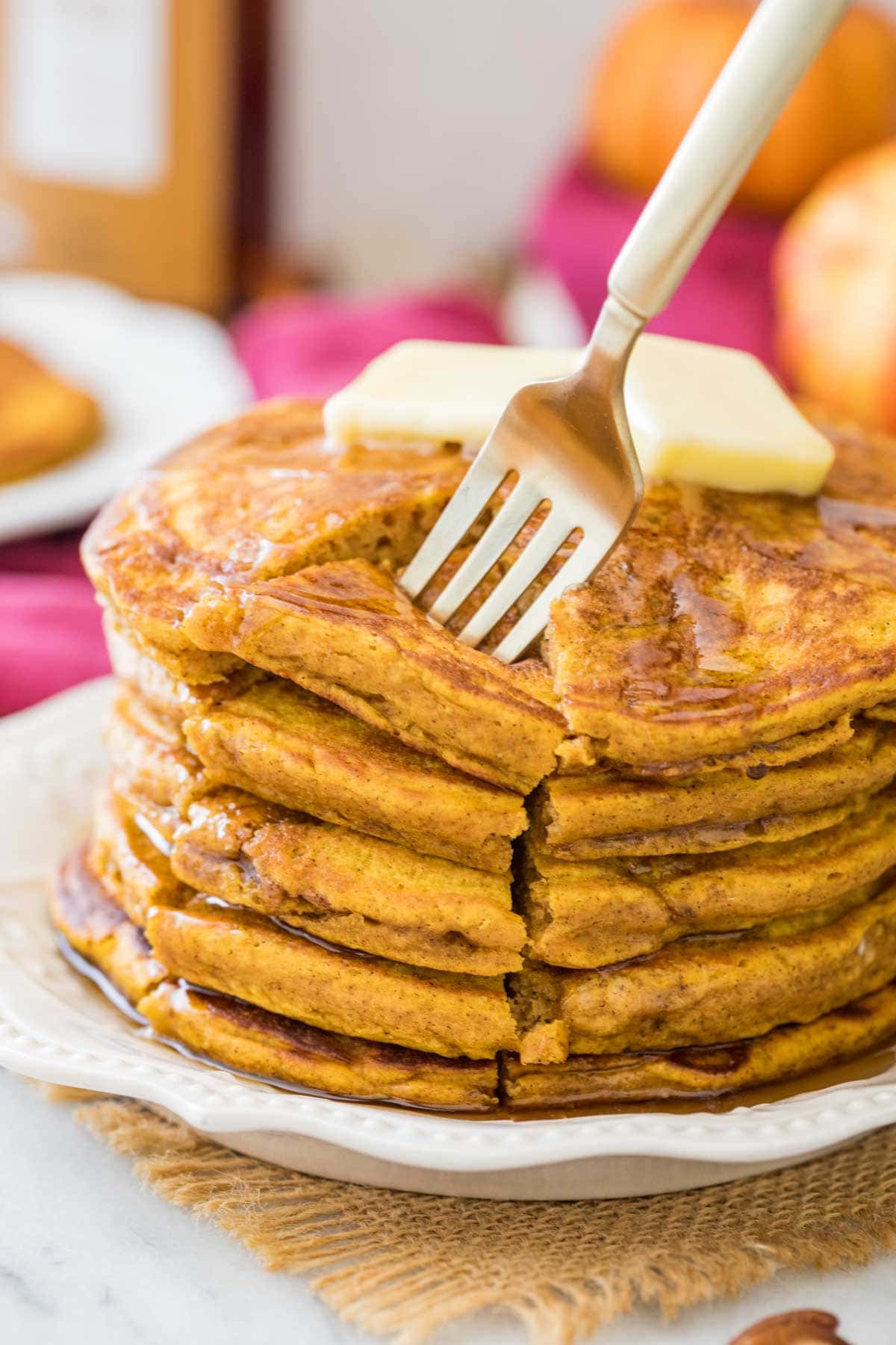 fork piercing a cut section from a stack of thick and fluffy pumpkin pancakes