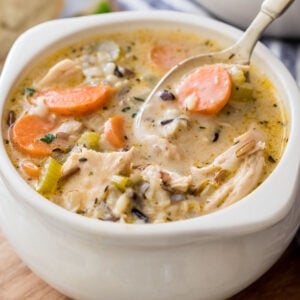 bowl of chicken and rice soup with spoon scooping a bite