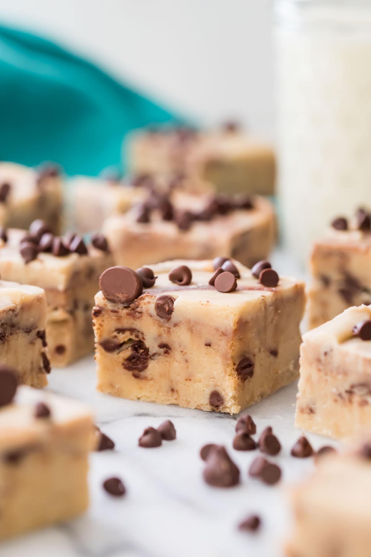square piece of cookie dough fudge topped with mini chocolate chips among other fudge squares