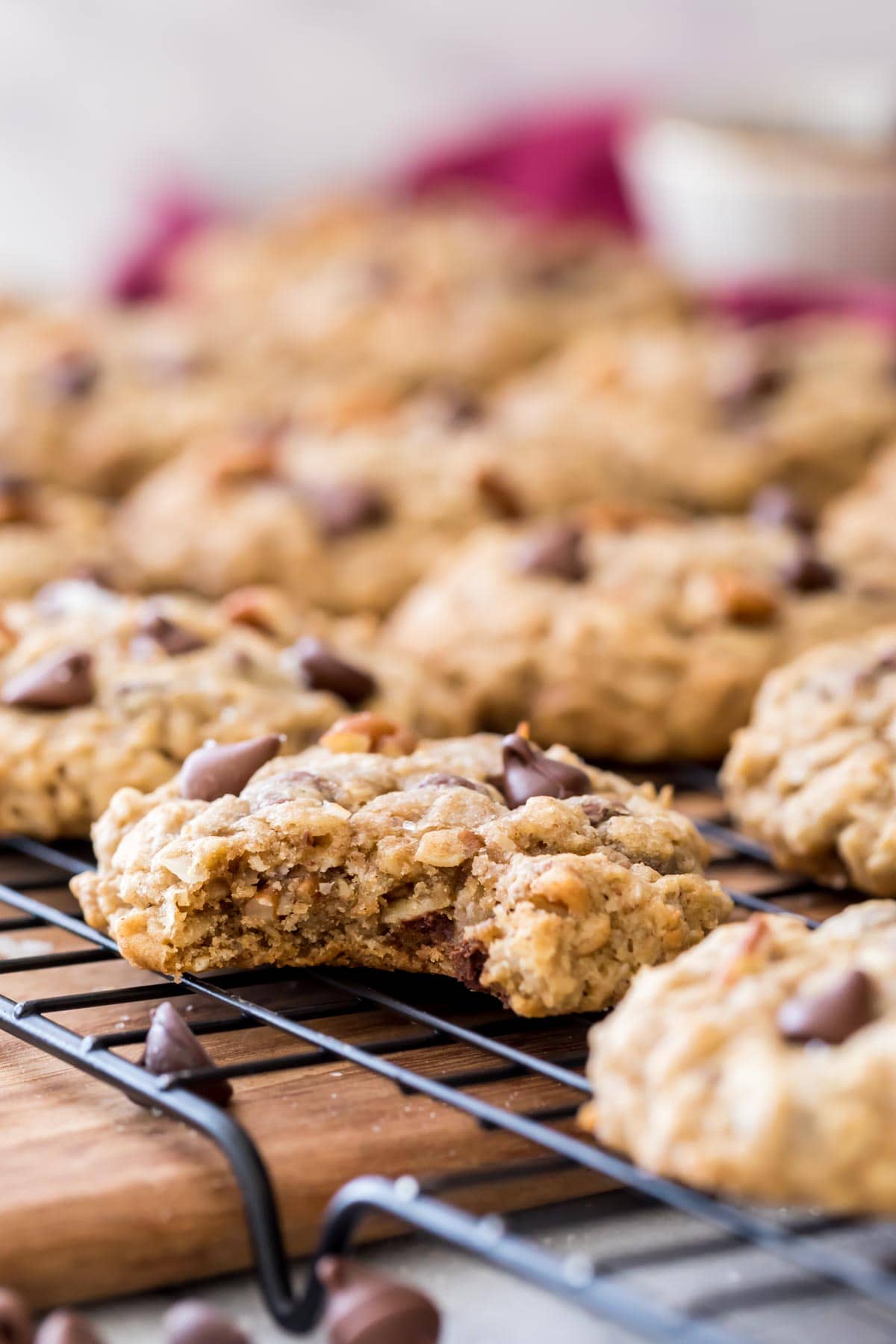 bitten cowboy cookie on cooling rack full of cookies