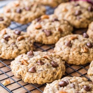 rows of cowboy cookies studded with chocolate chips, coconut, and pecan on black metal cooling rack