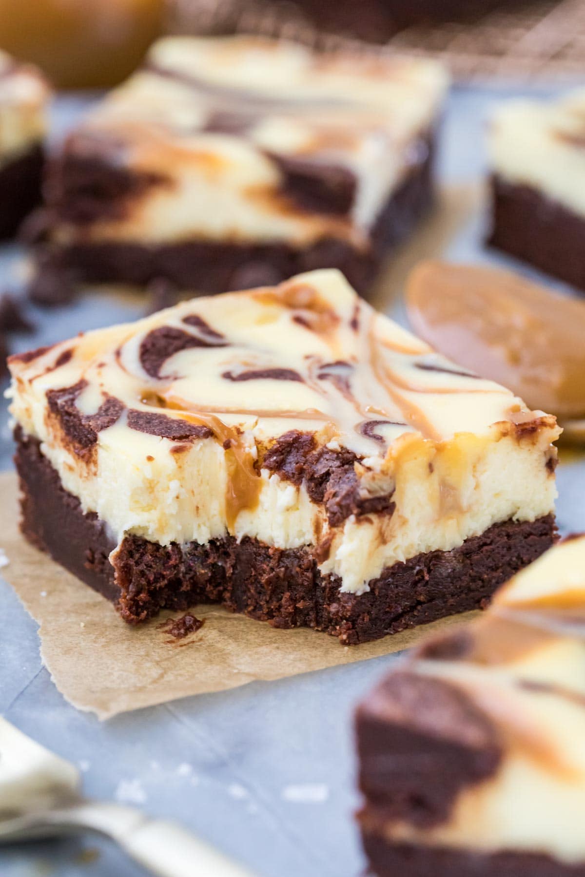 dulce de leche cream cheese brownie with one bite missing on parchment square