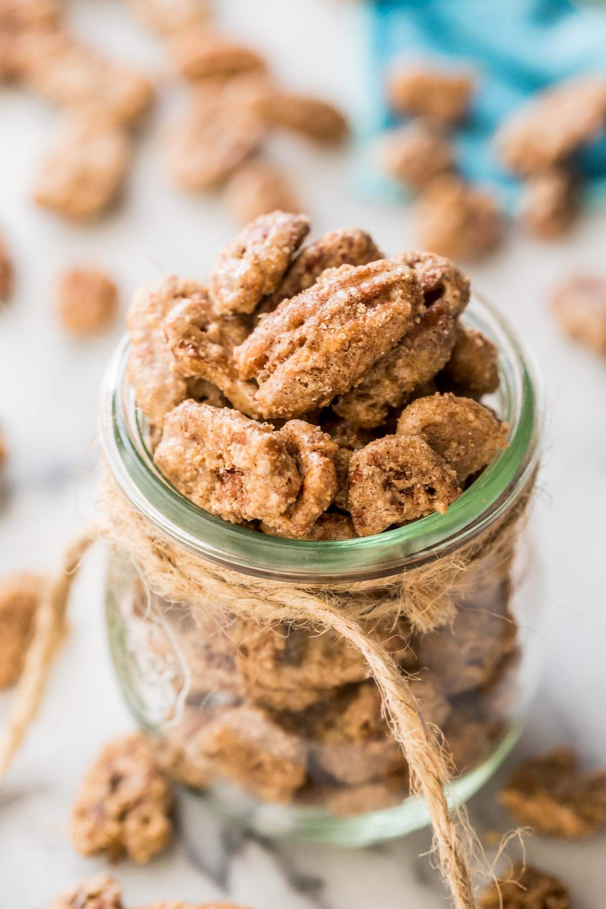 glass jar tied with twine filled with candied pecans
