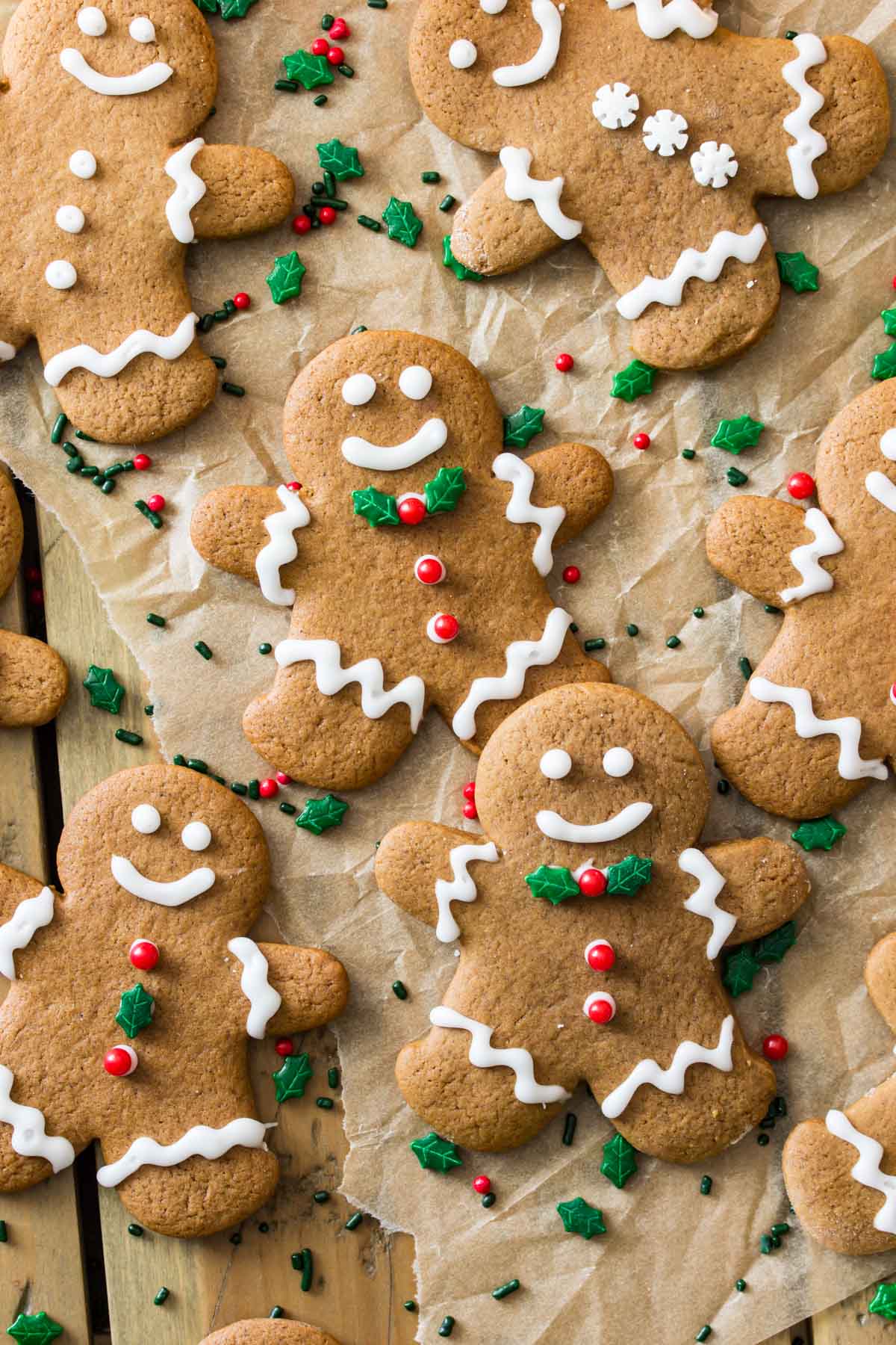 top-down view of decorated gingerbread men on brown parchment paper
