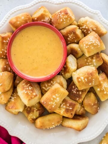 plate full of homemade soft pretzel bites served with a side of melted cheese