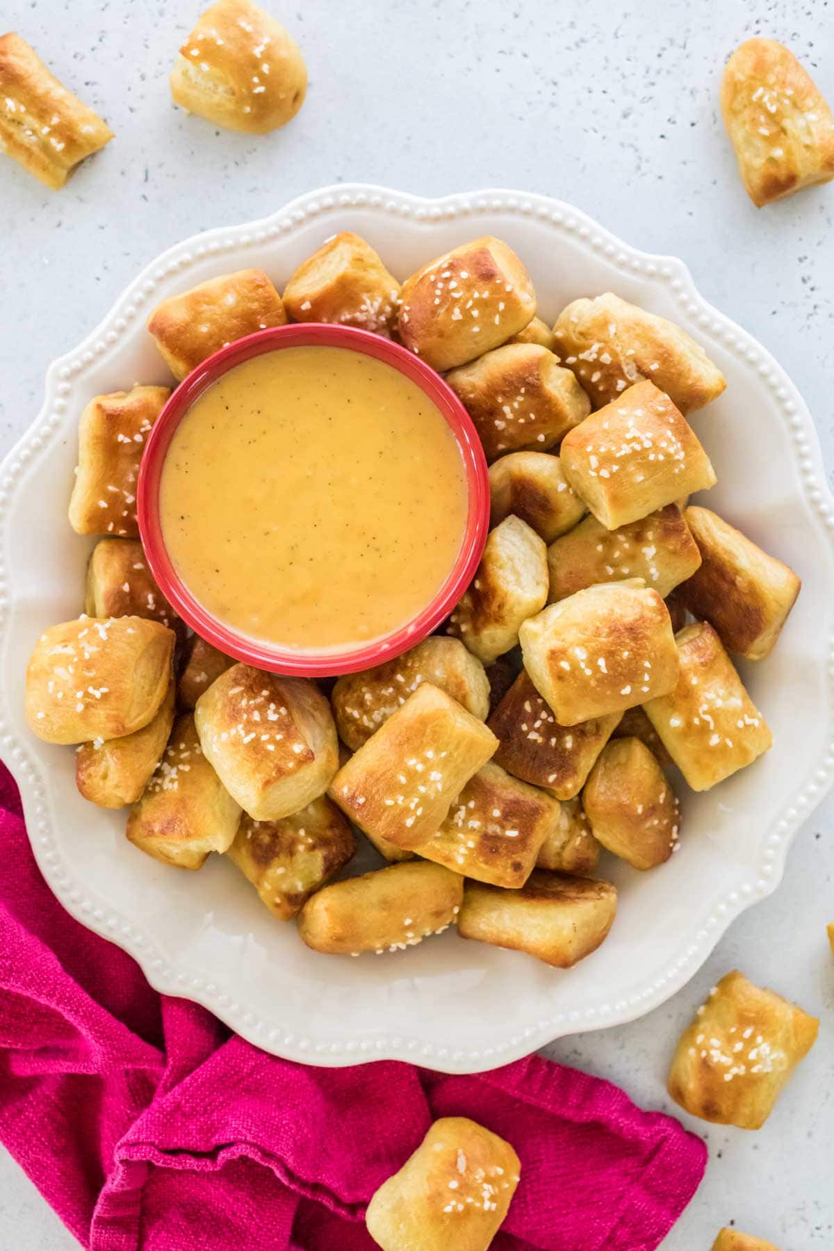 plate full of homemade soft pretzel bites served with a side of melted cheese