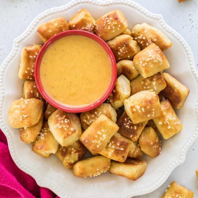 plate full of homemade soft pretzel bites served with a side of melted cheese