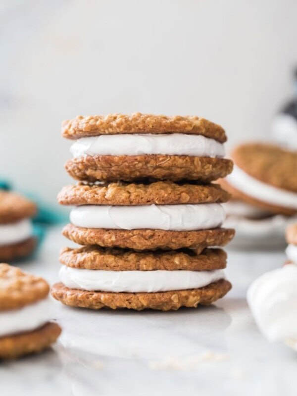 three oatmeal cream pies stacked vertically on top of each other with additional cream pies in the foreground and background