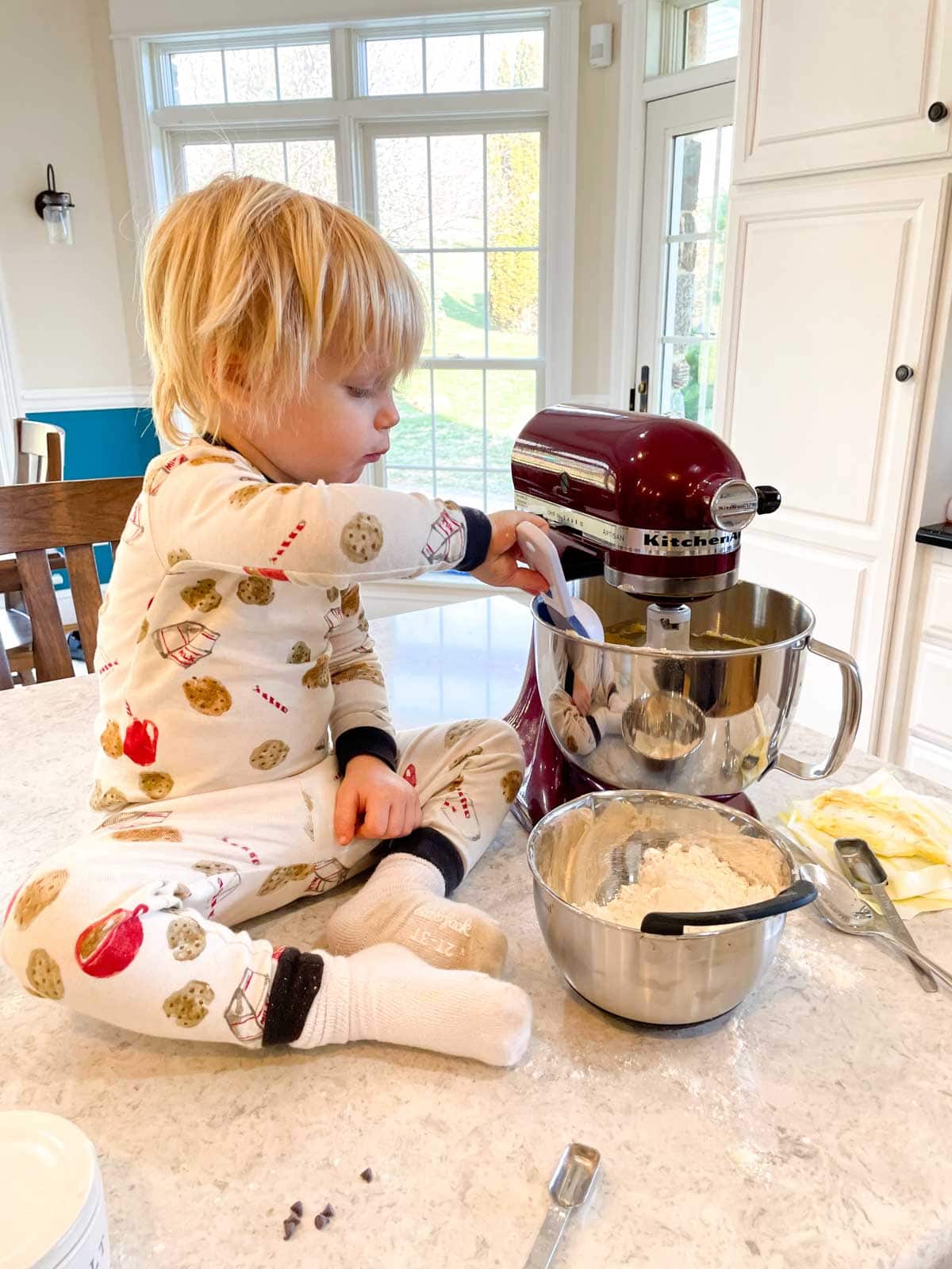 toddler boy pouring flour into stand mixer