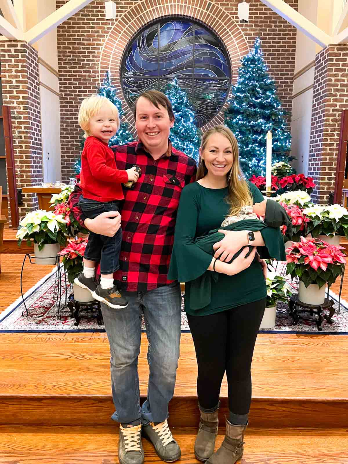 family of four in front of church alter