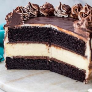 cross-section of a cheesecake stuffed cake consisting of dark chocolate cake layers sandwiching a classic cheesecake layer