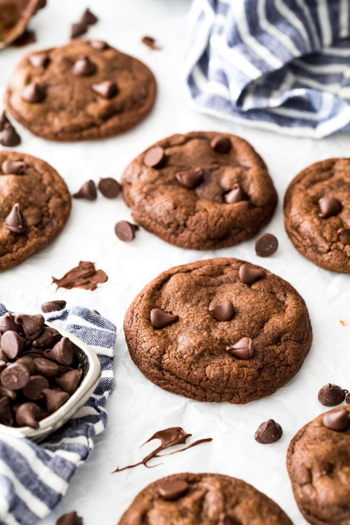 overhead view of fudge cookies on a white surface surrounded by chocolate chips