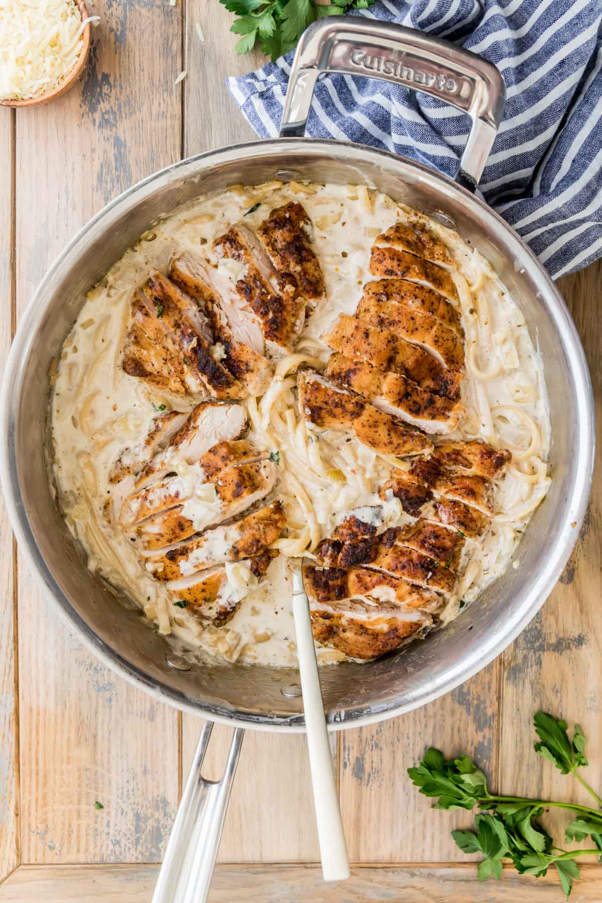 overhead view of a stainless steel skillet full of creamy chicken pasta