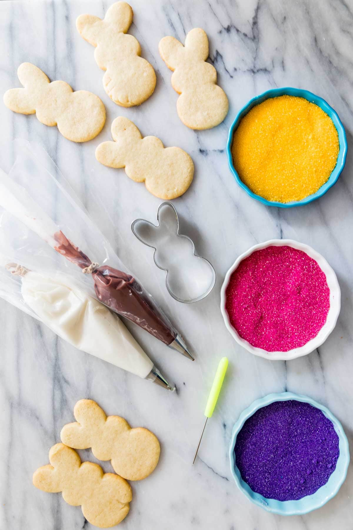 overhead view of ingredients for decorating bunny shaped sugar cookies