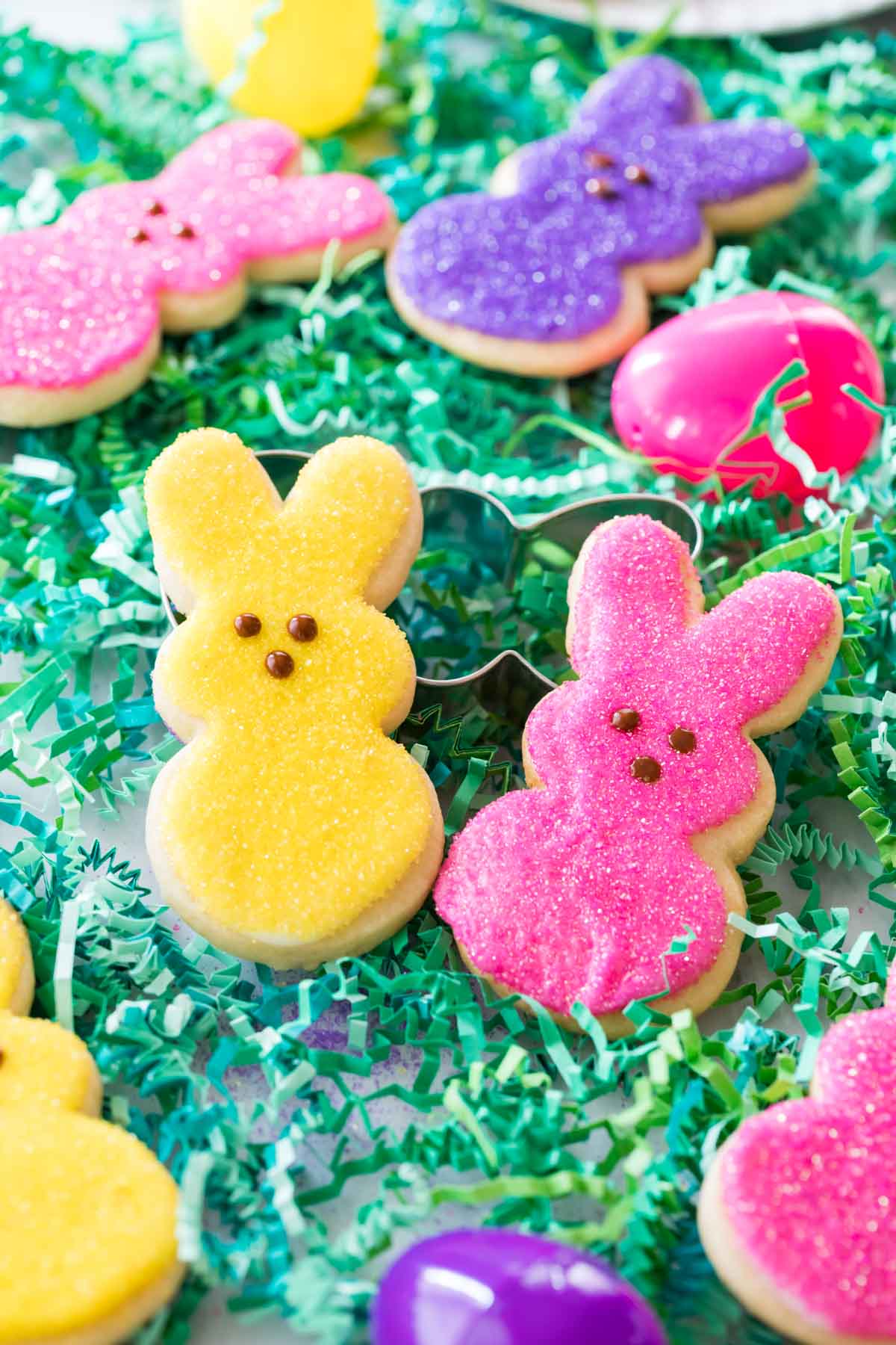 two yellow and pink rabbit shaped easter sugar cookies decorated to look like peeps marshmallows