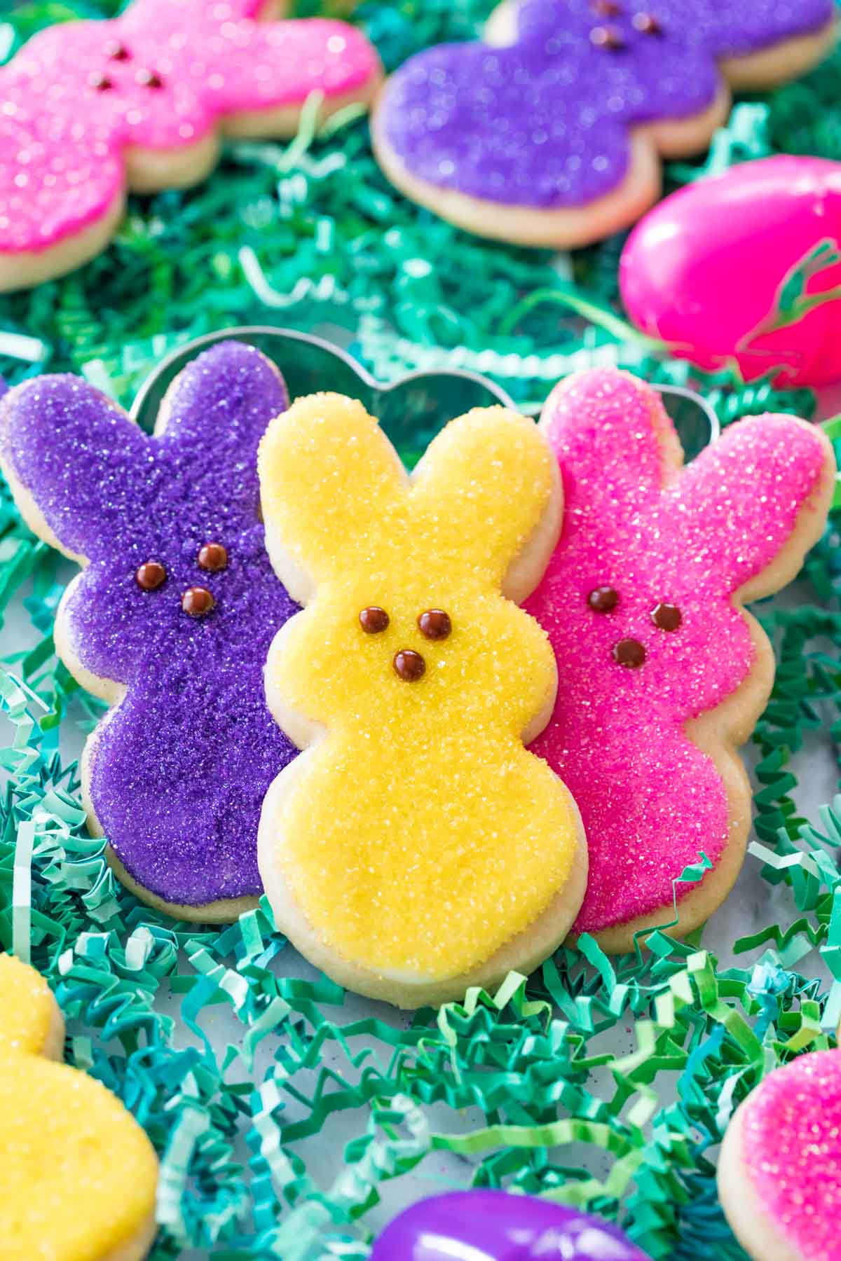 three colorful bunny shaped sugar cookies decorated to look like peeps marshmallows