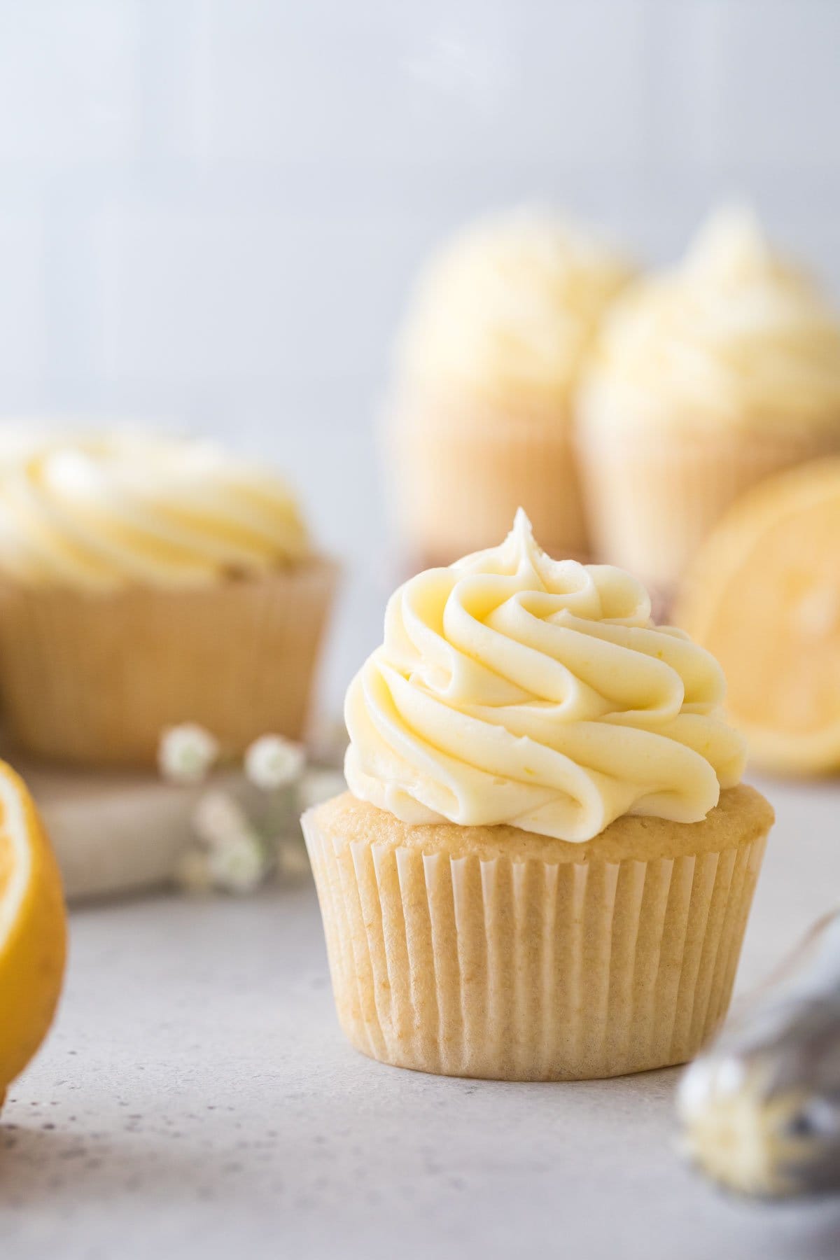 vanilla cupcake piped with a thick dollop of pale yellow frosting