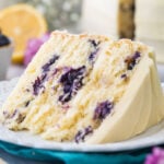 close-up view of a thick slice of lemon blueberry cake frosted with lemon frosting