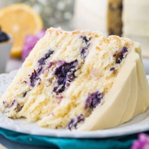 close-up view of a thick slice of lemon blueberry cake frosted with lemon frosting