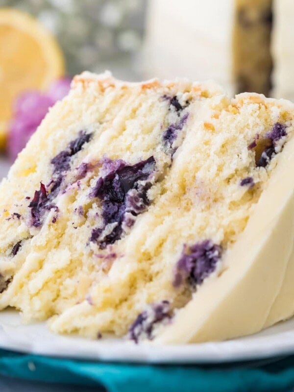 close-up view of a thick slice of lemon blueberry cake frosted with lemon frosting