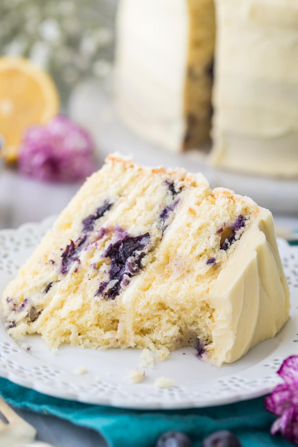 slice of lemon cake studded with blueberries missing several bites 