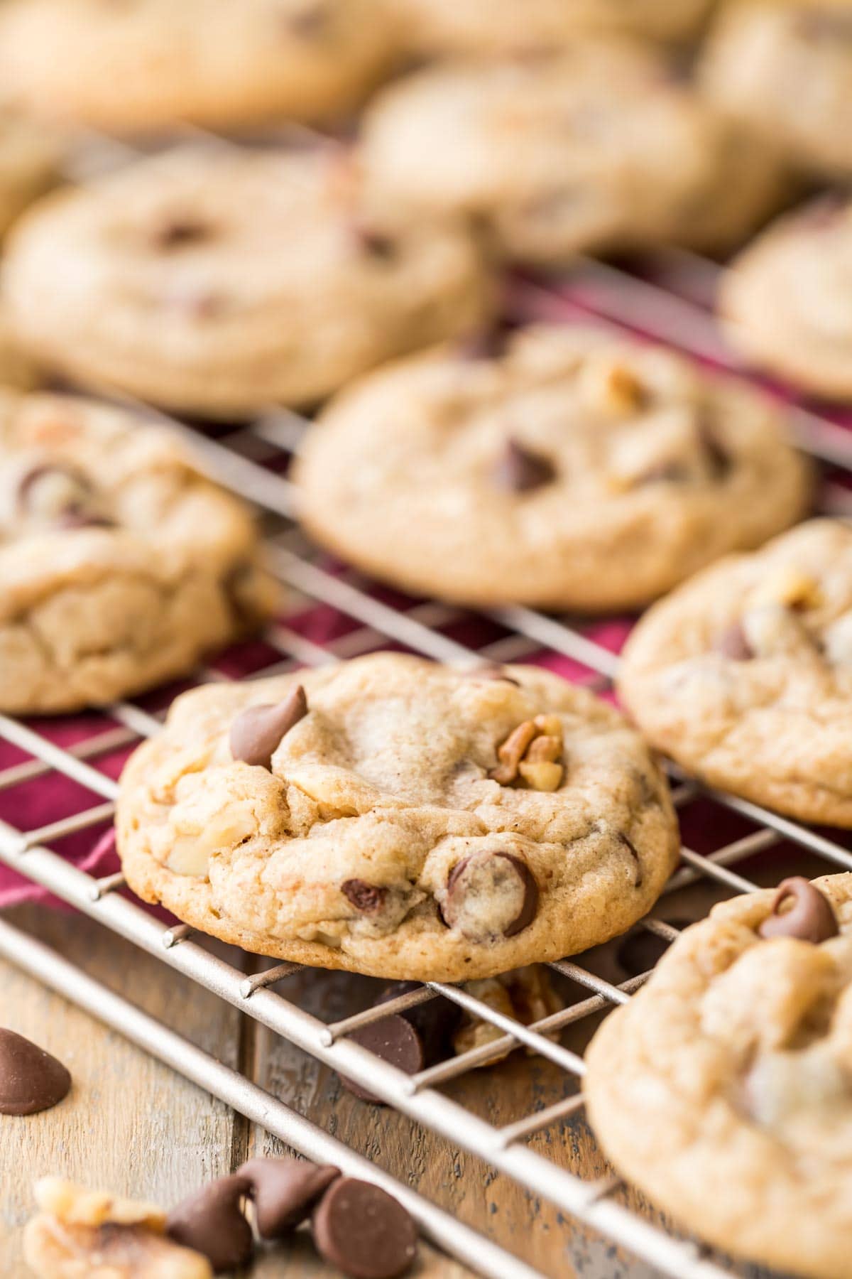 banana cookies filled with chocolate chips and walnuts resting on a cooling rack