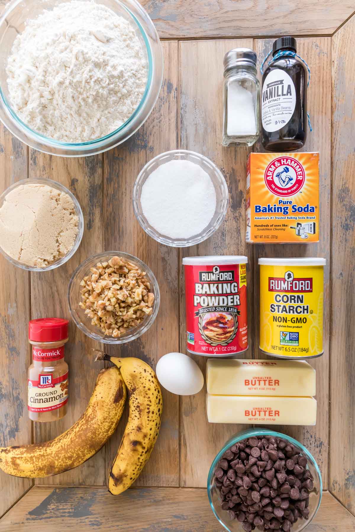 overhead view of ingredients including flour, brown sugar, walnuts, bananas, chocolate chips, and more