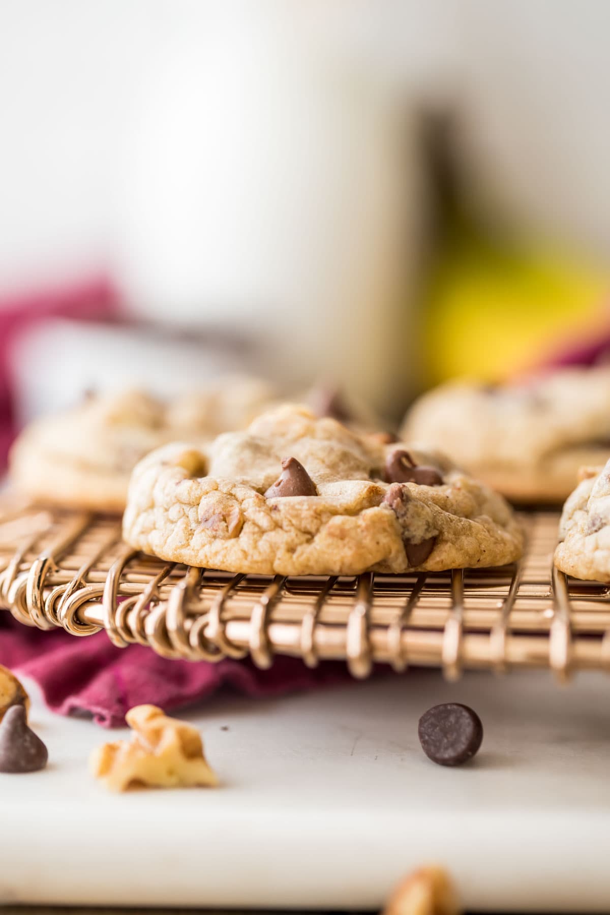 head-on view of cookies filled with walnuts and chocolate chips on a cooling rack
