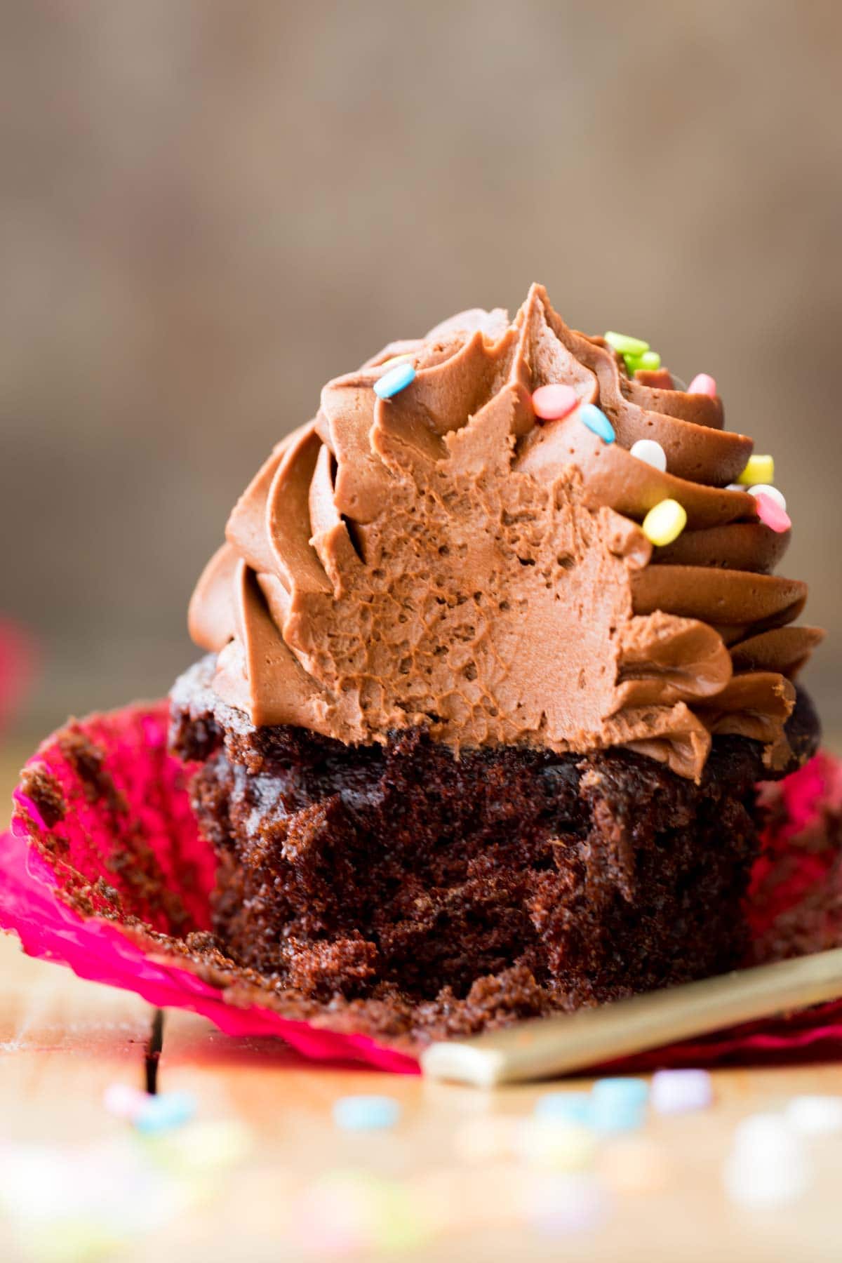 cupcake topped with lots of chocolate frosting missing a big bite
