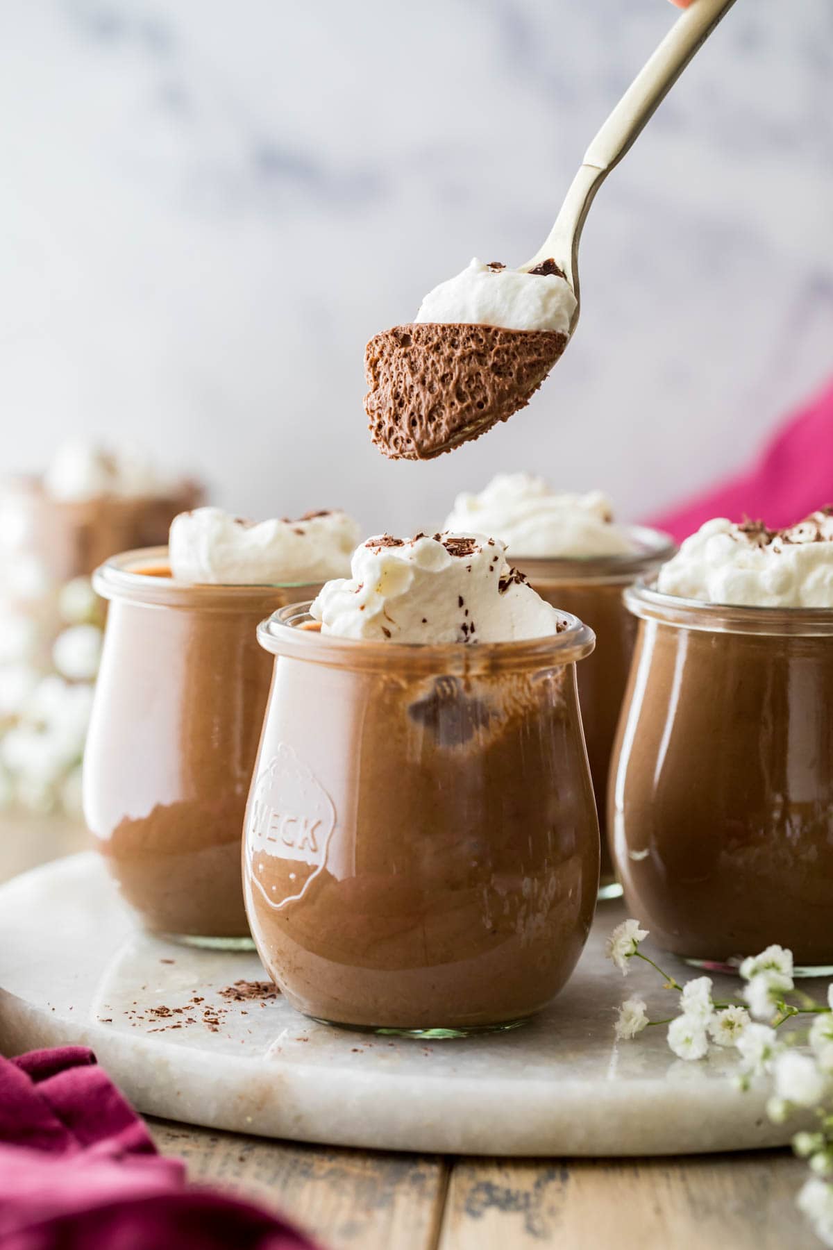 spoon scooping a bite out of a chocolate dessert topped with whipped cream