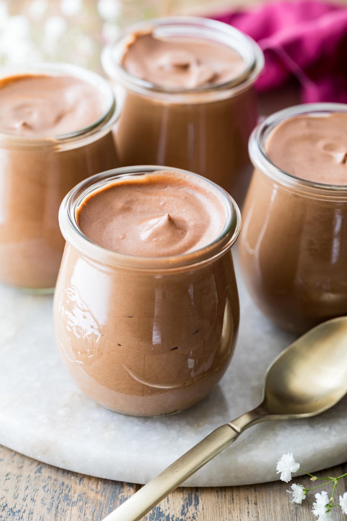 silky chocolate dessert served in small, tulip shaped glass jars with a spoon for scooping