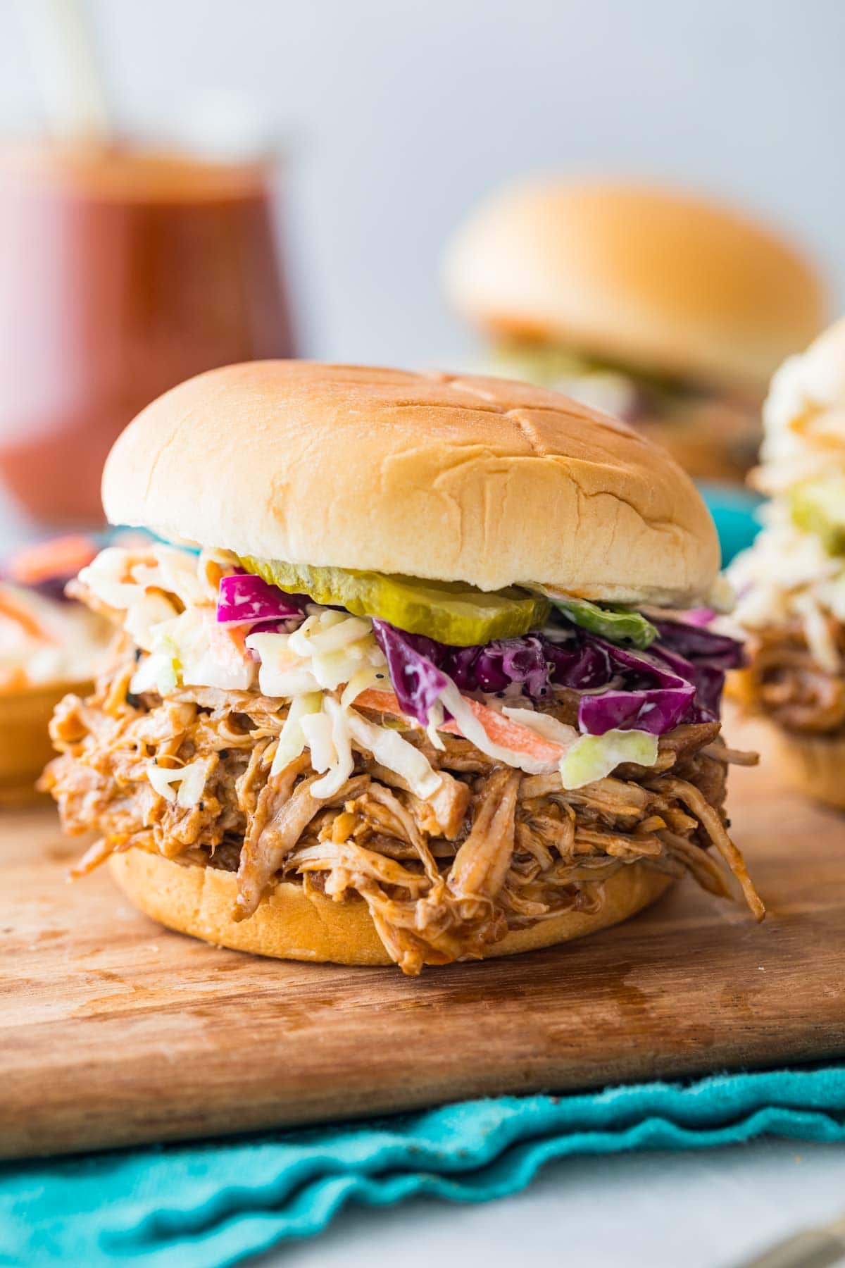 instant pot pulled pork on a sandwich topped with homemade coleslaw and pickles